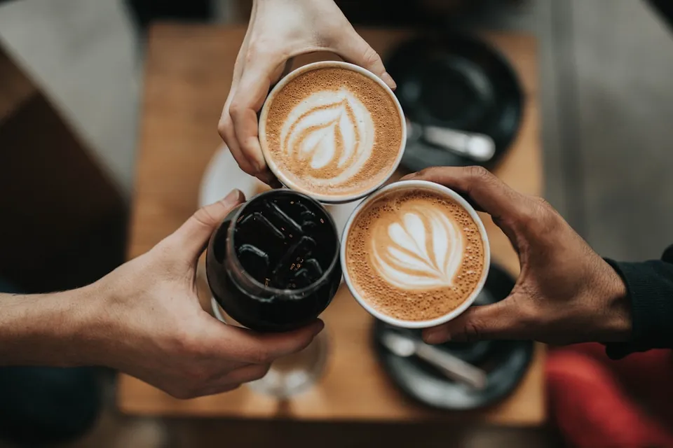 Two friends sharing flat whites around a table